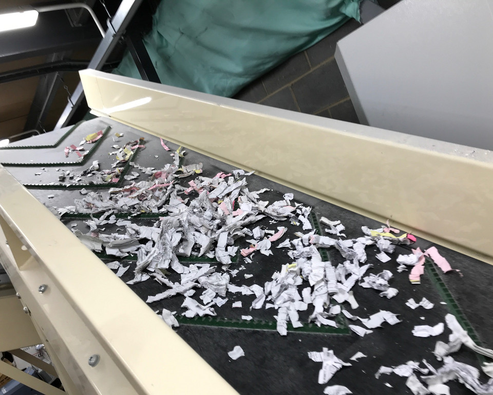 Paper being processed by an industrial shredder