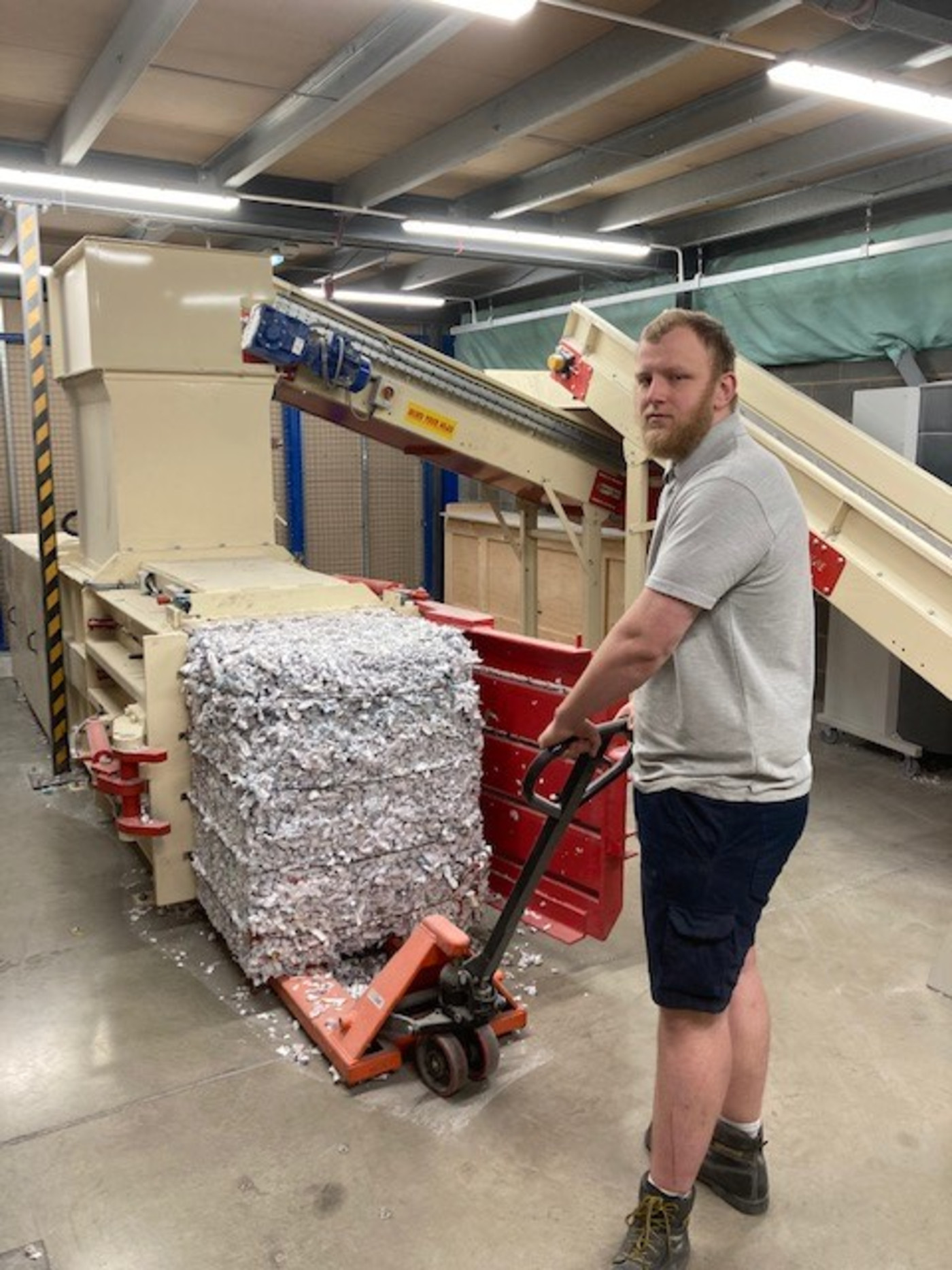 Bradshaw employee handling securely shredded material